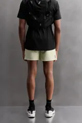 Shorts deportivos color verde oliva confeccionados en tejido técnico ligero y elástico. Cuenta con forro interior, cintura elástica ajustable con cordón, bolsillos laterales, bolsillo de seguridad en espalda con cierre de cremallera, bajo con aberturas laterales y logo estampado en la pierna.
