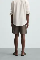 Bermuda negra de lino con calce relajado. Presenta cintura elástica ajustable con cordón, bolsillos frontales y un bolsillo trasero de plastrón.