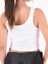 Musculosa corta negra de algodón con breteles anchos y escote cuadrado. Presenta un pequeño bordado de una mariposa azul en el centro del pecho.