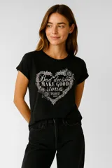 Remera negra de manga corta con cuello redondo y estampado frontal con la frase "Bad decisions make good stories" dentro de un corazón de flores.
