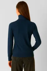 Polera de tejido acrílico color marrón, de manga larga y cuello tortuga.