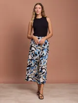 Pantalón capri estampado con flores en tonos celeste, blanco y negro. Tiene pretina elastizada en la parte trasera y bolsillos delanteros.