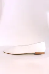 Ballerinas blancas de cuero con suela plana color madera.