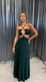 Vestido largo de fiesta color verde esmeralda, con escote halter cruzado, abertura en el abdomen y falda acampanada.