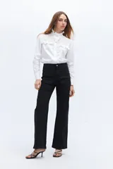 Pantalón de jean negro de corte recto con bolsillos delanteros tipo parche y costura central.