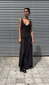 Vestido largo negro de microtul, corte evasé y breteles finos.