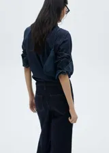Pantalón de jean azul oscuro, corte wide leg, tiro medio y largo hasta el tobillo. Incluye cinturón con hebilla y cuatro bolsillos.