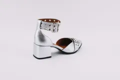 Zapato plateado de cuero con taco cuadrado, punta fina y pulsera con hebilla y ojales.