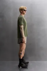 Camiseta deportiva verde militar confeccionada en tejido estructurado, ligero y elástico. Tiene cuello redondo, manga corta y bajo con aberturas laterales. Incluye logo estampado en el bajo.
