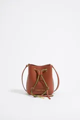 Bolso tipo bucket negro de cuero con tachas plateadas y flecos largos. Tiene cierre de cordón ajustable y logo de la marca en el frente.