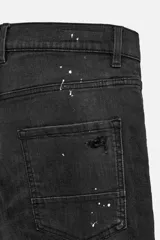 Pantalón de jean negro con corte skinny fit, cinco bolsillos, lavado con efecto roto y cierre frontal con cremallera y botón.