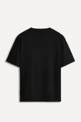 Camiseta negra de algodón con cuello redondo y manga corta. Tiene un bolsillo de parche en el pecho con el logo del 50 aniversario.