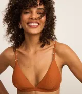 Top de bikini color ladrillo, de microfibra texturizada, con corte triangular fijo, breteles ajustables adornados con mini adornos y copas desmontables.