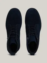 Botines Tommy Hilfiger de hombre, color azul marino, confeccionados en ante con interior de poliéster y suela de goma. Presentan cordones, logo Hilfiger en el tobillo y detalle distintivo en el talón.