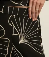 Pantalón wide leg negro con estampado de hojas en color crema, cintura elastizada y bordado de follaje.