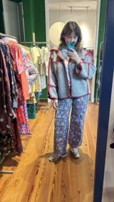 Chaqueta gris de paño de lana con detalles de crochet rojo, corte cuadrado y cuello camisero.