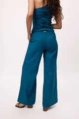 Pantalón recto color amarillo con rayas verticales blancas.