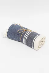 Lona de playa rectangular con diseño estampado a rayas rojas y blancas.