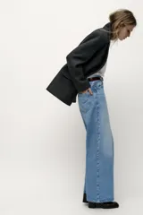 Pantalón de jean celeste de corte ancho, tiro alto y cinco bolsillos.