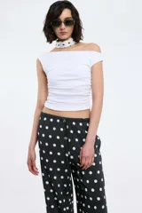 Pantalón negro con lunares blancos, de corte recto y cintura elastizada con lazo ajustable.