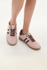 Zapatillas deportivas color rosa con detalles en marrón, cordones marrones y suela color caramelo.