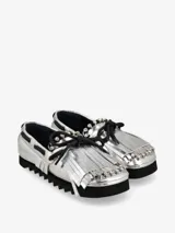 Zapato náutico plateado con flecos y cordones negros, y suela track negra.