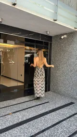 Vestido midi de encaje floral color beige sobre base negra, con cuello halter y falda con vuelo.