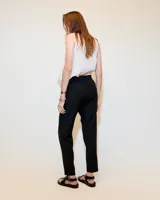 Babucha sastrera color beige confeccionada en tela italiana, de tiro medio y largo hasta los tobillos. Diseñada con cintura elastizada, cartera falsa, bolsillos laterales funcionales y piernas tipo pitillo con raya de aplomo.