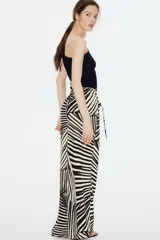 Pantalón de punto de corte holgado con piernas amplias, tiro alto, cintura elástica y cordón para ajustar. Estampado de hojas de palmera en blanco y negro.