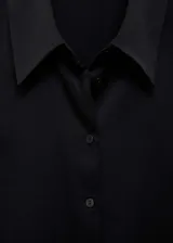 Camisa color crema de manga larga con puños abotonados y cuello camisero.
