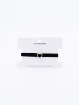 Gargantilla choker de terciopelo negro con dije de corazón dorado y cadena de alargue dorada.