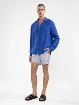 Camisa celeste de lino, de manga larga con botones de coco y parche de la marca.