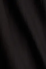Vestido corto negro sin mangas, de corte evasé, con escote redondo, abertura de cerradura con botón oculto en la nuca y bajo recto. Parcialmente forrado.