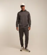 Buzo deportivo gris con capucha ajustable, manga larga ajustada, bolsillo canguro, detalles en recortes y textura.