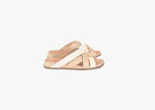 Sandalias bajas de cuero color beige con tiras cruzadas en cuero color blanco.
