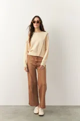 Sweater de manga larga color beige con cuello redondo y detalle de líneas superpuestas en diagonal.