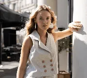 Chaleco color crema de lino con cuello solapa y doble botonadura con botones marrones.