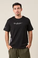 Remera blanca de algodón con estampado frontal que incluye el texto "The Boston Est. 1997" y un texto vertical más largo en el lateral.