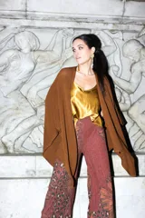 Pantalón de mujer de corte palazzo, color marrón con estampado de flores anaranjadas y lurex.