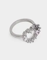 Anillo plateado con forma de corazón, adornado con strass blancos y gemas rosas y violetas.