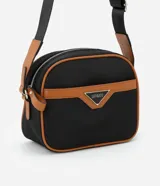 Cartera bandolera negra con detalles en marrón, confeccionada en poliéster certificado Grs y poliuretano. Presenta un aplique metálico triangular, asa larga ajustable y cierre por cremallera.