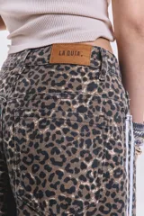 Pantalón de jean de corte ancho con estampado animal print y rayas blancas laterales.
