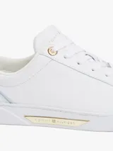 Zapatillas Tommy Hilfiger de piel blanca con detalles dorados en el talón y la lengüeta.