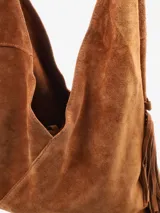 Cartera de diseño amplio y silueta relajada, color negro, con detalles de flecos en los laterales. Cuenta con un asa superior integrada y una correa desmontable para llevar al hombro o cruzada.