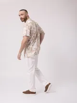 Camisa de hombre de manga corta con cuello cubano y estampado de hojas en tonos beige y blanco.