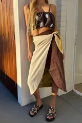 Falda pareo de lino combinada en tono chocolate, pistacho y crudo, con diseño envolvente y agarre lateral.