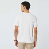 Remera blanca de punto jacquard con cuello redondo y mangas cortas.