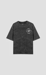 Remera negra con efecto nevado, corte oversize y estampado de Pennywise, globos y la frase 'Todos Flotan'.