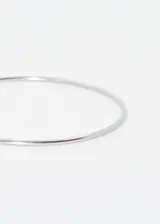 Pulsera rígida tipo esclava de acero quirúrgico hipoalergénico, color plateado.