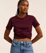 Remera tipo t-shirt de algodón, color beige claro, con cuello redondo y mangas cortas dobladas.